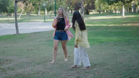 two women walking and talking in a park