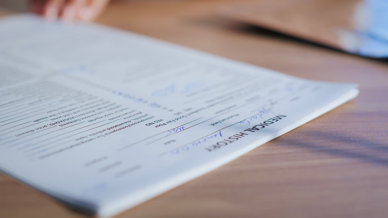 Hands writing medical history papers on desk closeup. Doctor signing insurance