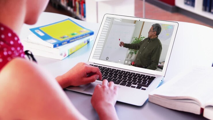 Caucasian female student using laptop on video call with male teacher