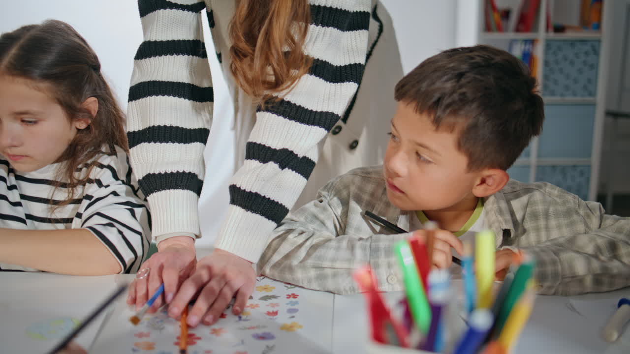 Little painters creating masterpiece with teacher in art workshop studio closeup