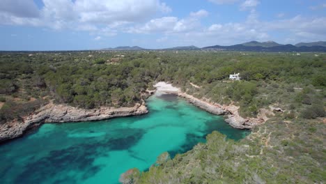 Flug-über-Türkisfarbenes-Wasser-In-Richtung-Des-Weißen-Sandstrandes-Von-Cala-Sa-Nau