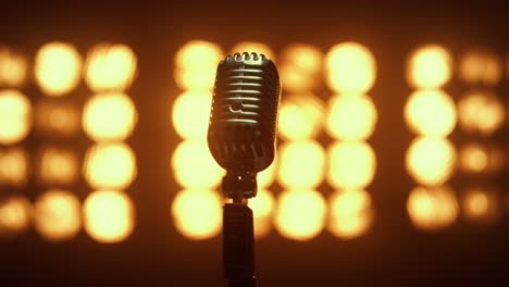 retro mic placed empty scene illuminated lamps close up. microphone in nightclub