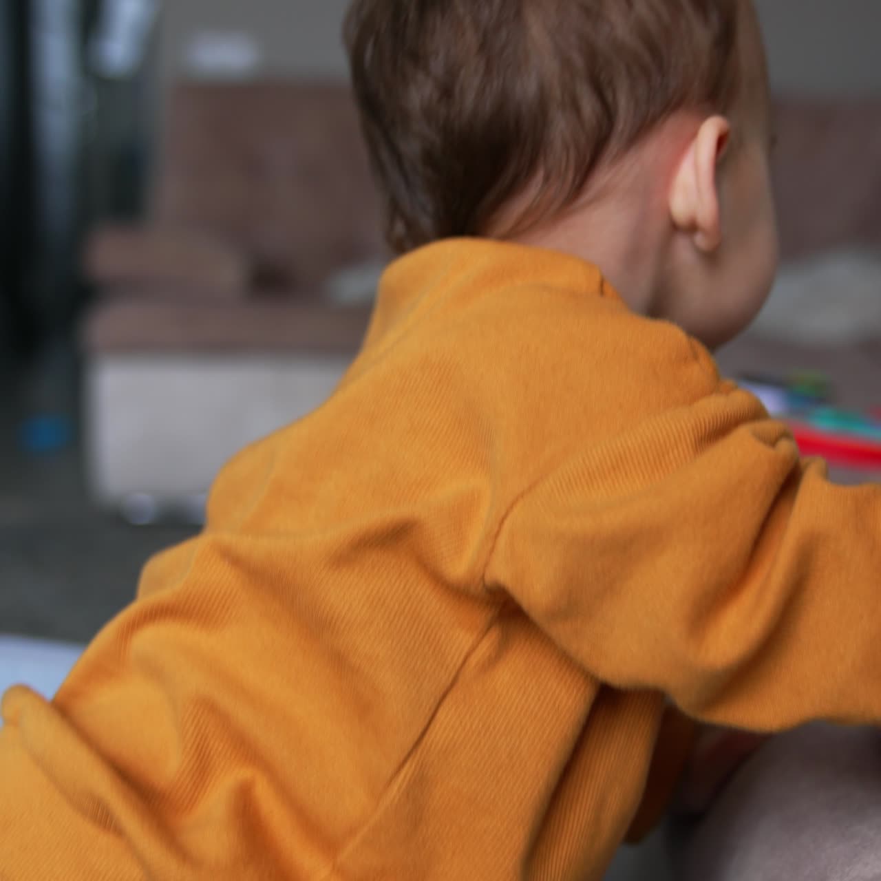 Bambino gioioso seduto in una vasca asciutta che sorride in modo adorabile. Un bel bambino cerca di uscire dalla piscina tenendo un ciuccio in mano