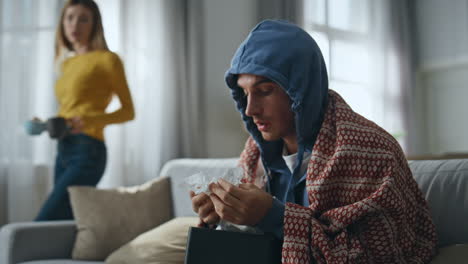 sick man sneezing alone at home closeup. ill guy getting flu at living room