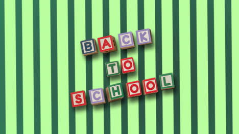 back to school on blocks against rotating green striped background