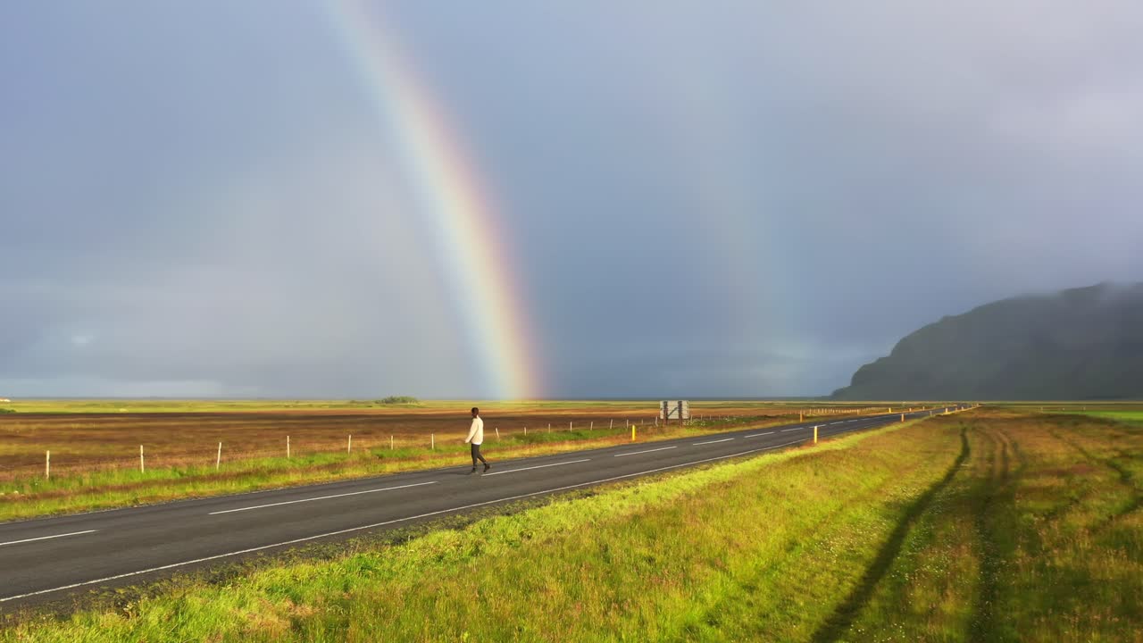 mujer feliz frente a un arco iris