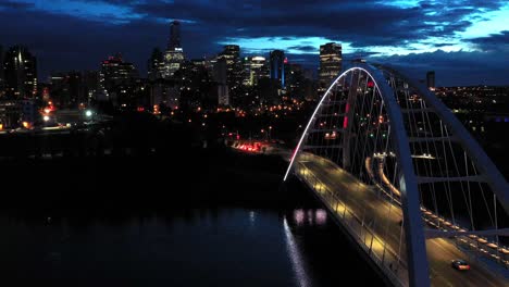 aerial drone view of the edmonton walterdale bridge over the north saskatchewan river during a summer night and the downtown skyline in the background