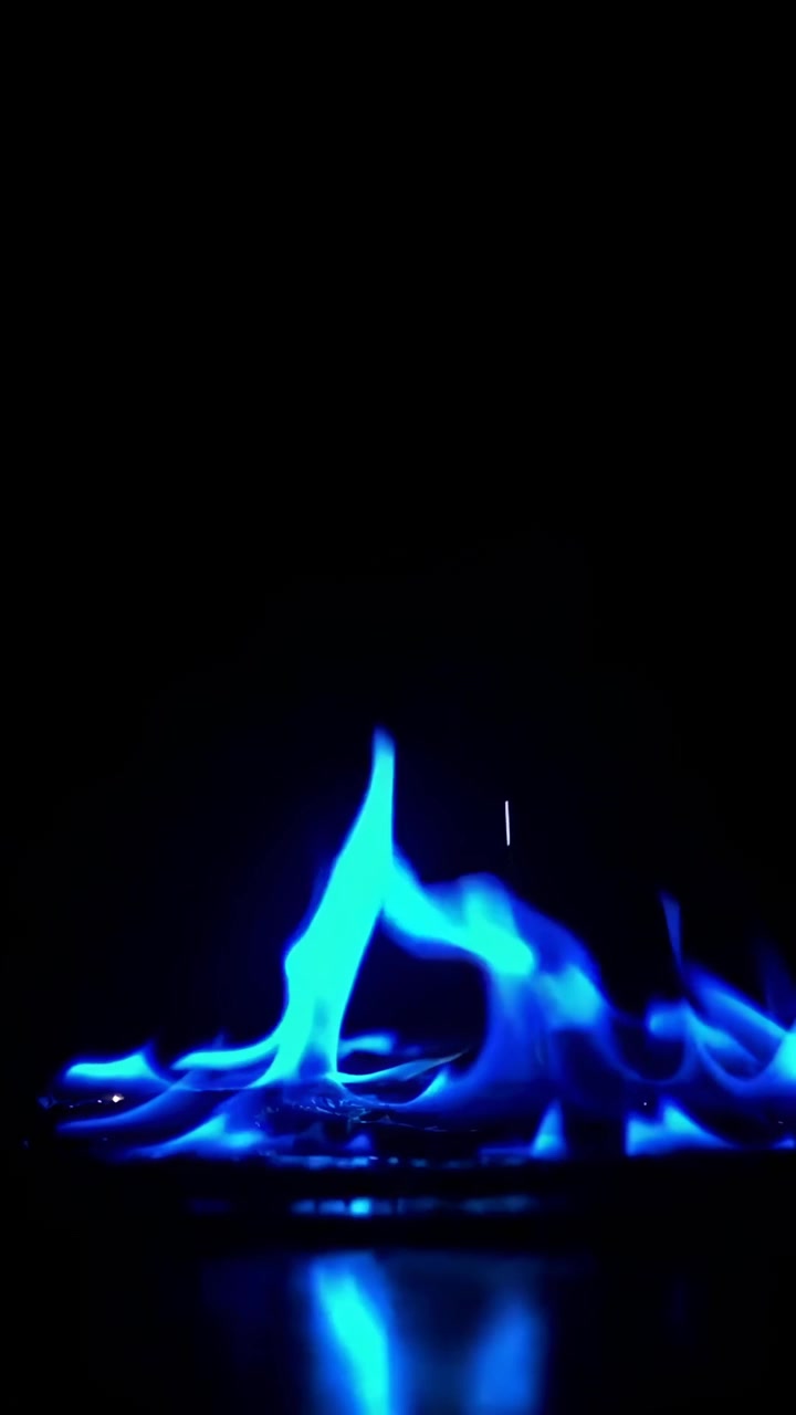 Fiamme blu dinamiche danzanti su una superficie scura riflettente