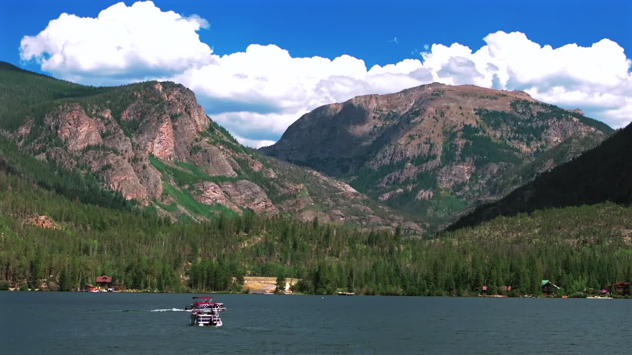 Summer Grand Lake Granby pontoon boating crossing sailboat aerial drone Colorado Gravel Rocky Mountains National Park entrance sunny morning daytime clouds lake homes blue sky sunny clouds static