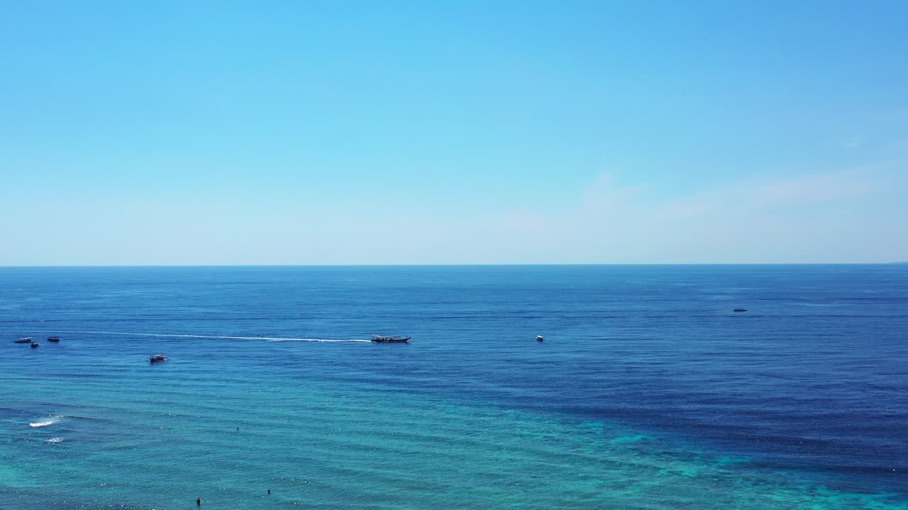 푸른 바다를 가로질러 수평으로 항해하는 배를 보여주는 바하마 해변 - 와이드 샷