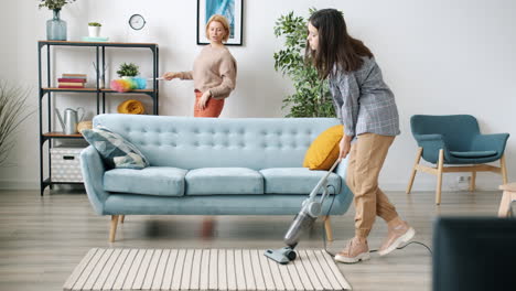 mother and daughter cleaning the living room