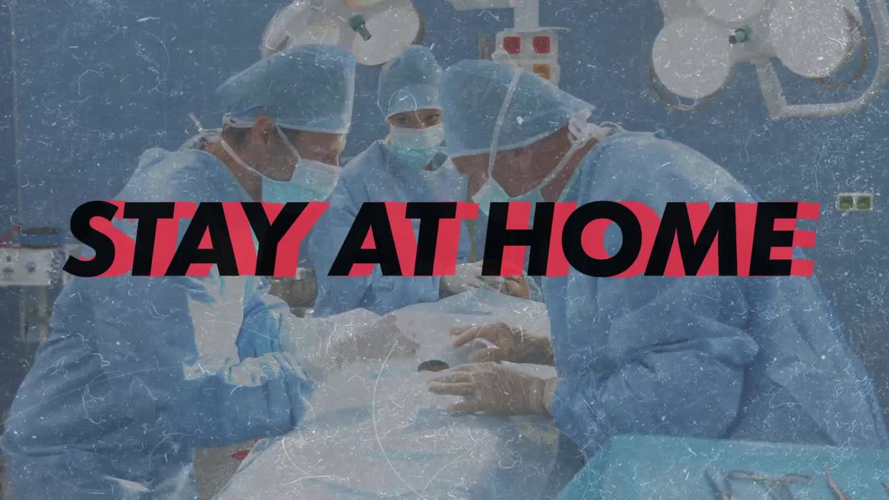 permanezca en casa y esté a salvo texto contra el equipo de cirujanos que realizan la cirugía en la sala de operaciones