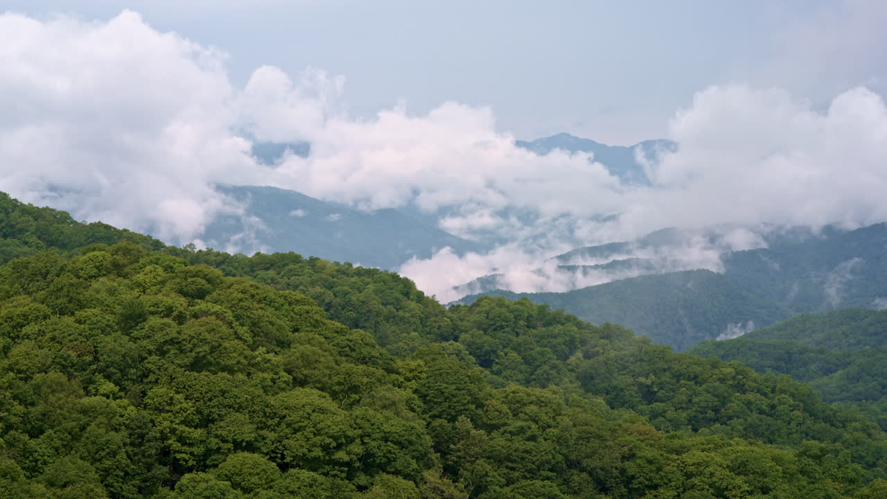 Mist and clouds form a natural veil over the ancient ridges — drone capture