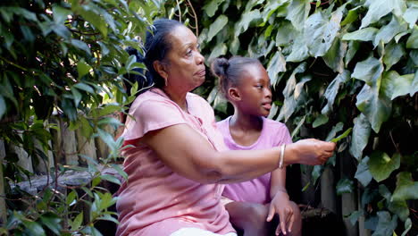 grandmother and granddaughter exploring garden, enjoying nature and bonding together, copy space