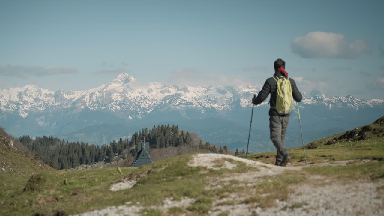 captura de cámara de un excursionista caminando por un camino hacia la cabaña