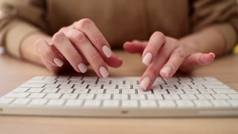 hands typing on a white computer keyboard