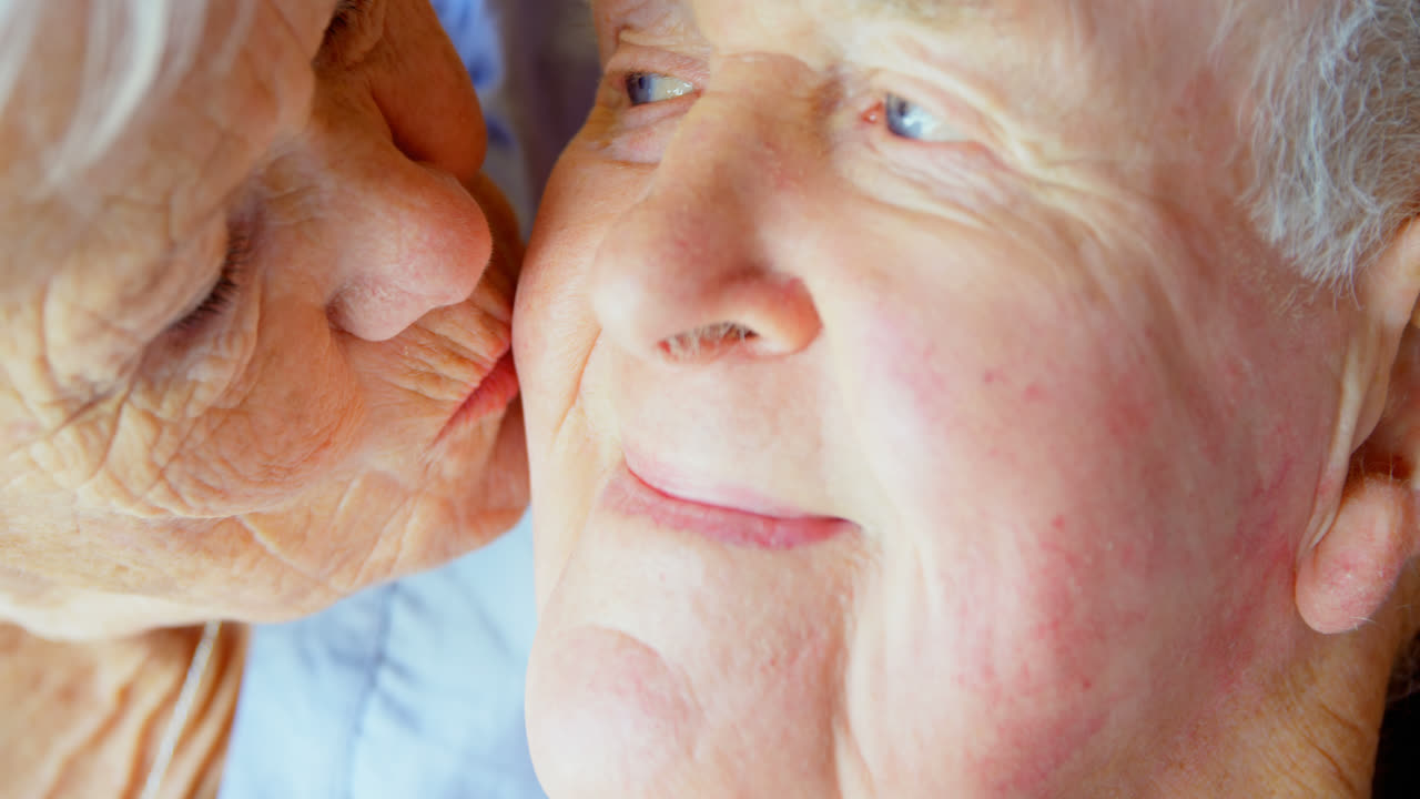 편안한 집에서 노인 남자와 키스하는 백인 노인 여성의 클로즈업 4k