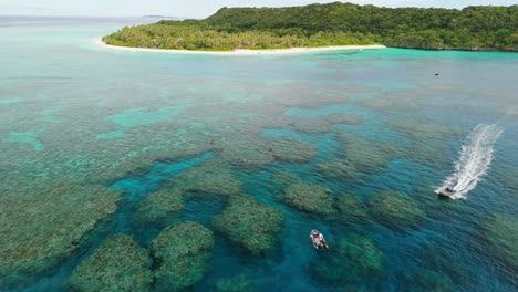 zodiac boat with group of snorkelers swimming around coral reef in fiji