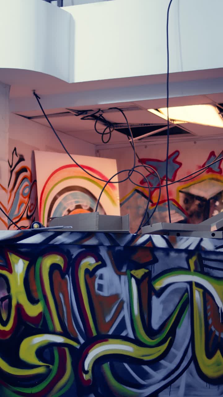 Vídeo vertical de arte de grafiti y escombros dispersos en un lugar de urbex sin nadie