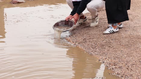 people panning for gold in muddy water