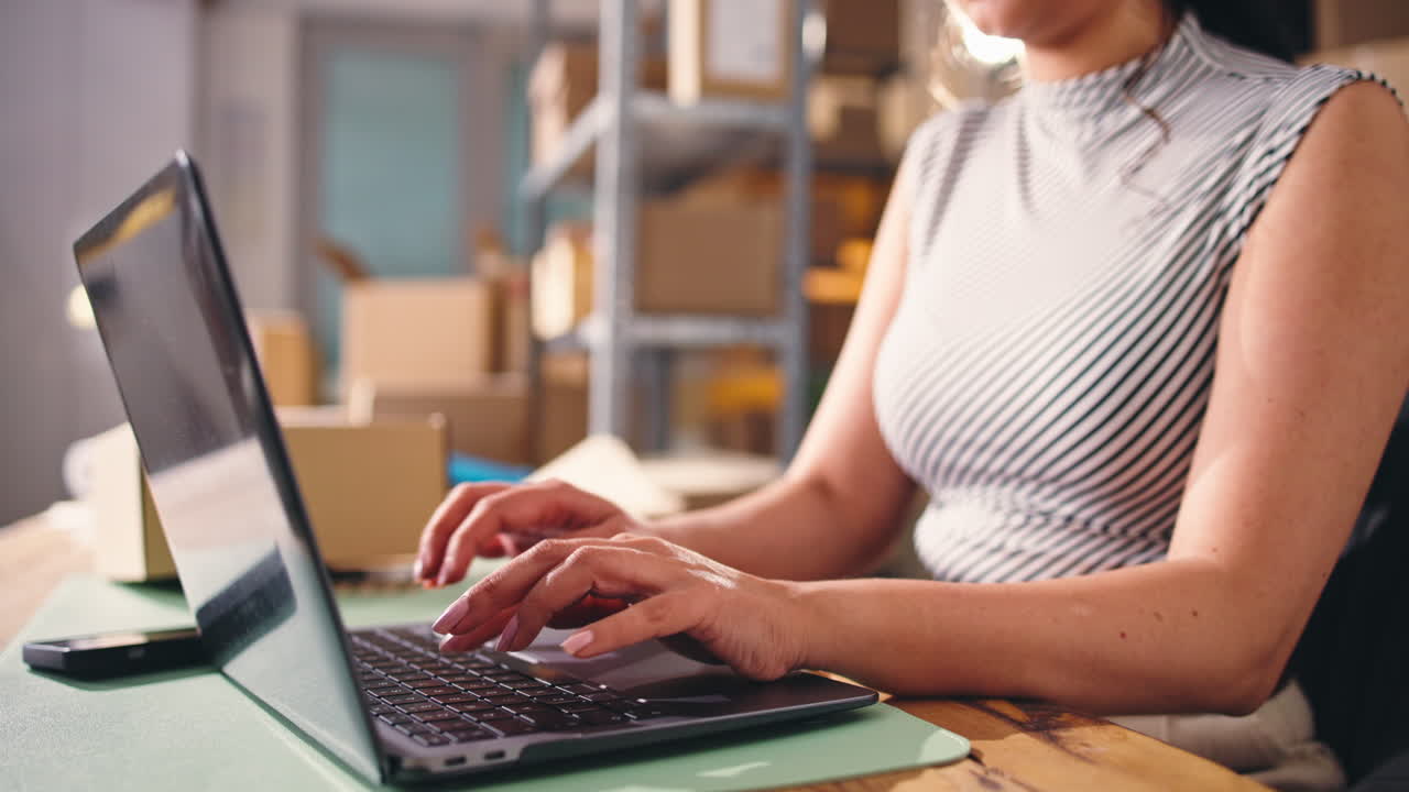 Mulher digitando no notebook em um escritório de pequena empresa
