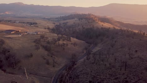 Retracción-Aérea-De-Un-Camino-Sinuoso-En-Las-Montañas-Tehachapi-De-California-Al-Amanecer.