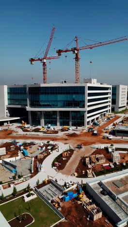 modern building under construction with cranes