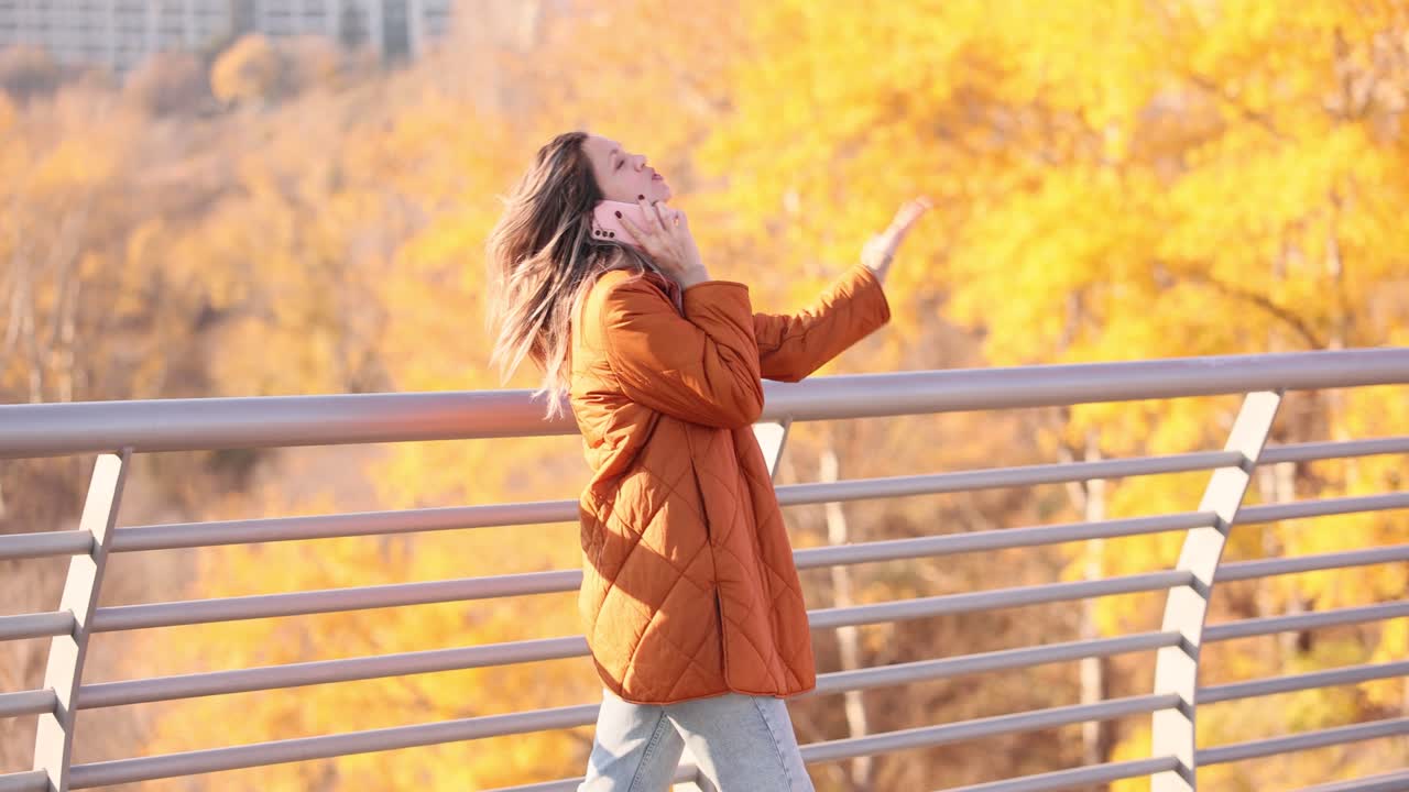 Woman talking on phone in autumn park