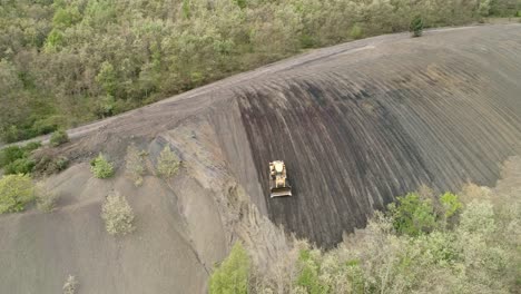 bulldozer working on a steep slope, aerial view