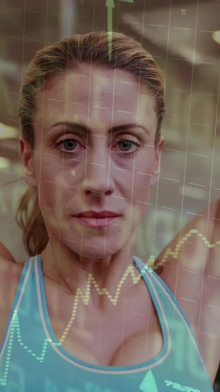 Vertical video: Woman raising arms in gym, holding stretch and engaging line charts for feedback