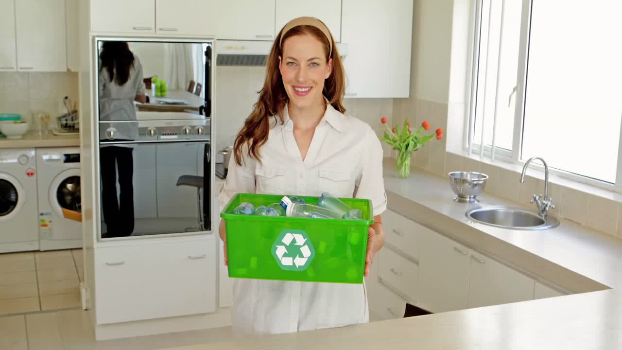 hermosa morena mostrando su caja de materiales reciclables