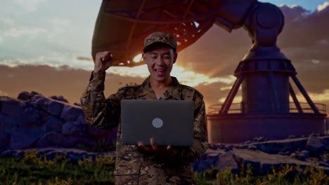 asian man soldier looking at the laptop then screaming goal celebrating while standing with satellite dish