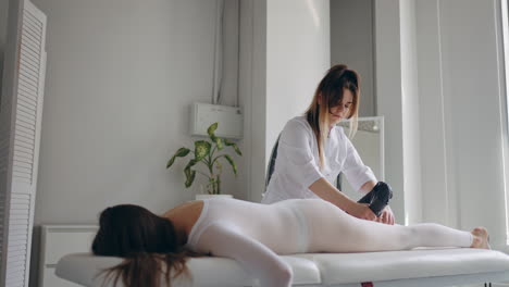 anti-cellulite treatment with modern lpg technology woman master is massaging female patient ass and hips