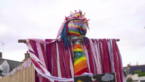traje colorido y espantapájaros de cara pintada de arco iris que se muestran al aire libre en tiempos de la pandemia de covid-19 - tiro de ángulo bajo