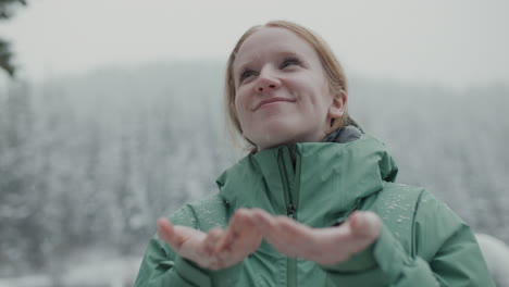 woman enjoying snowfall in snowy forest