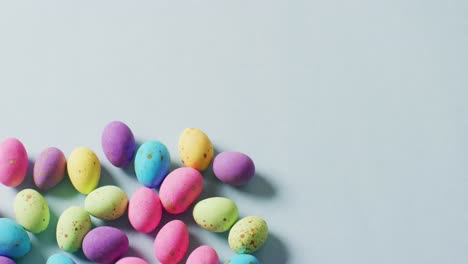 multiple colorful easter eggs on green background with copy space