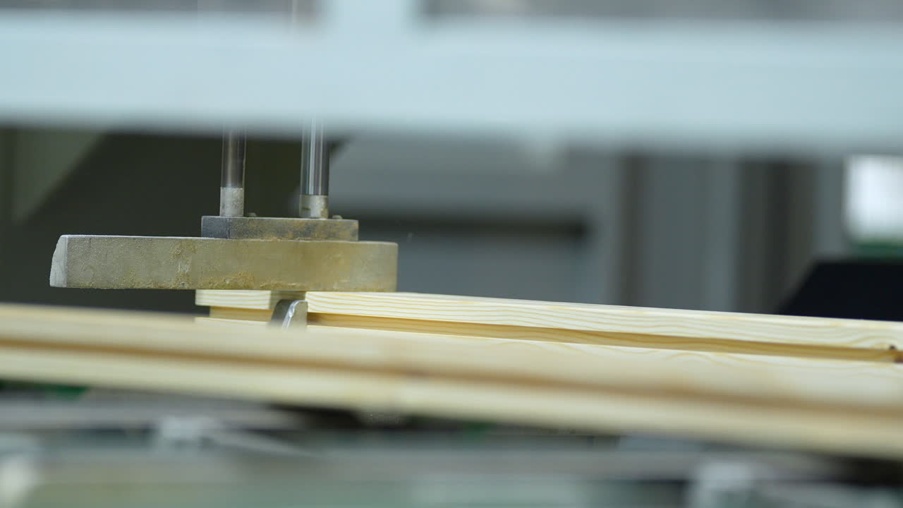 Close up of a CNC woodworking machine precisely handling and cutting light wood planks. Ideal for industrial manufacturing and carpentry technology concepts
