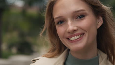 caucasian woman looking at the camera and smiling outdoors.