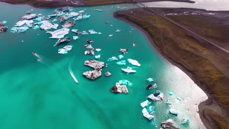 un vuelo de avión no tripulado sobre una laguna glacial en islandia con icebergs flotantes y barcos cruzando