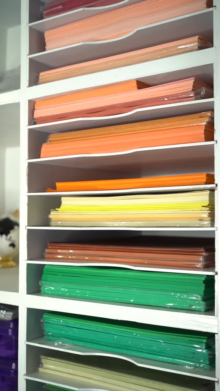 Colorful Paper Stacks Organized on White Shelves