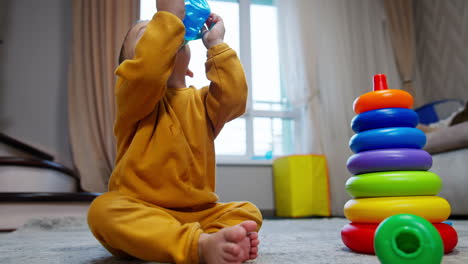 baby playing with toys and drinking