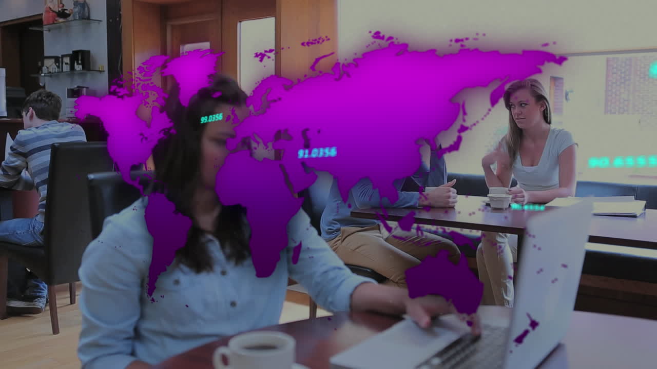 una mujer está sentada en una cantina bebiendo café y usando una computadora portátil