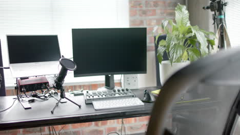 close up of desk with computer, laptop and microphone at home, slow motion