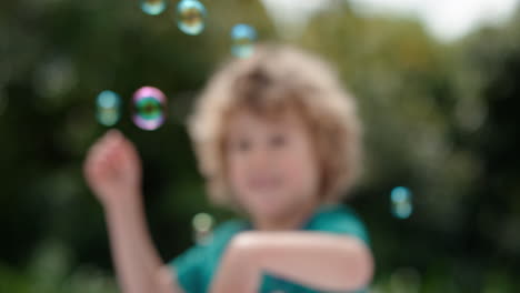 Süßer-Kleiner-Junge,-Der-Spielerisch-Seifenblasen-Fängt,-Die-Mit-Einem-Glücklichen-Kind-Schwimmen,-Das-Spaß-Daran-Hat,-Blasen-Im-Sonnigen-Park-Zu-Platzen,-Unbeschwertes-Kindheitsspiel-4k