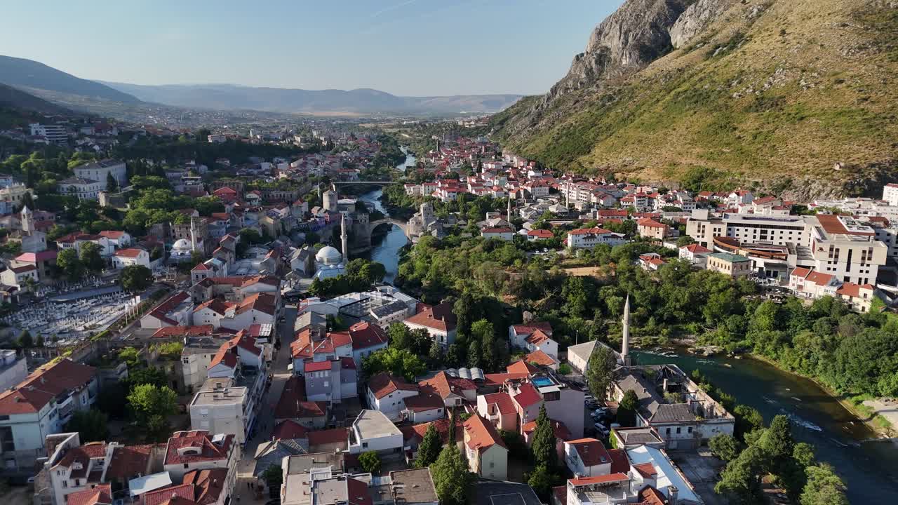 Letecký pohled dronem na město Mostar v Bosně a Hercegovině, balkánské zemi, se starým mostem Stari Most přes řeku Neretvu, v létě, v červenci.
