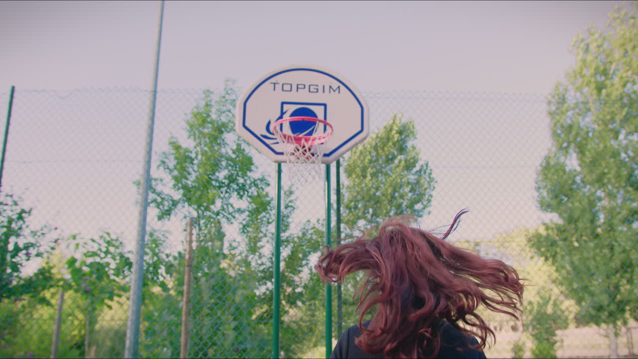 cancha de baloncesto chica pelirroja dribla la pelota hacia el aro y anota en cámara lenta