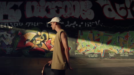 Attractive-man-skateboarding-at-skate-park.-Teenager-looking-on-camera.