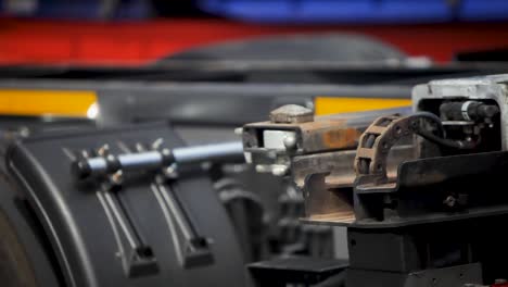 Close-up-view-of-a-well-worn-machine-part-in-a-workshop-with-blurred-colorful-background