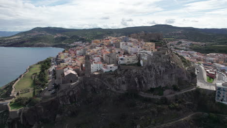 city of castelsardo, certeña: flying towards this impressive city built on a mountain and with its colorful houses and historic tower