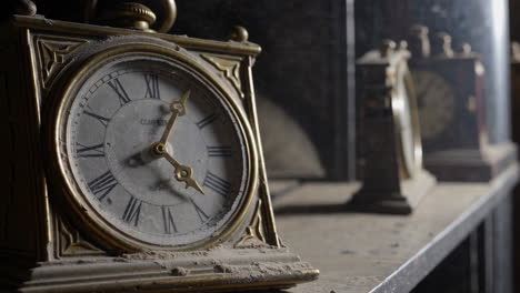 dusty antique clocks on a shelf